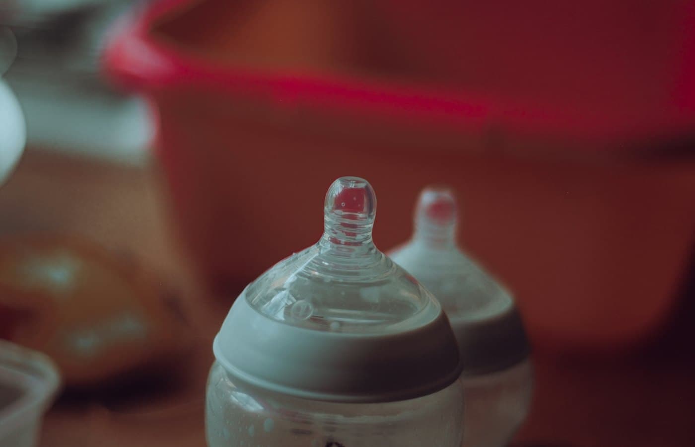 Clear plastic feeding bottle on red table