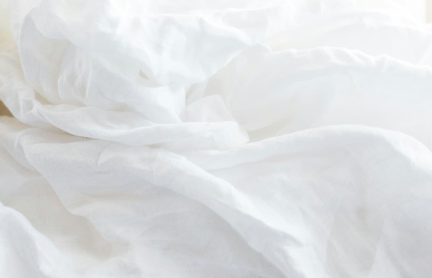 A close up of a bed with white sheets