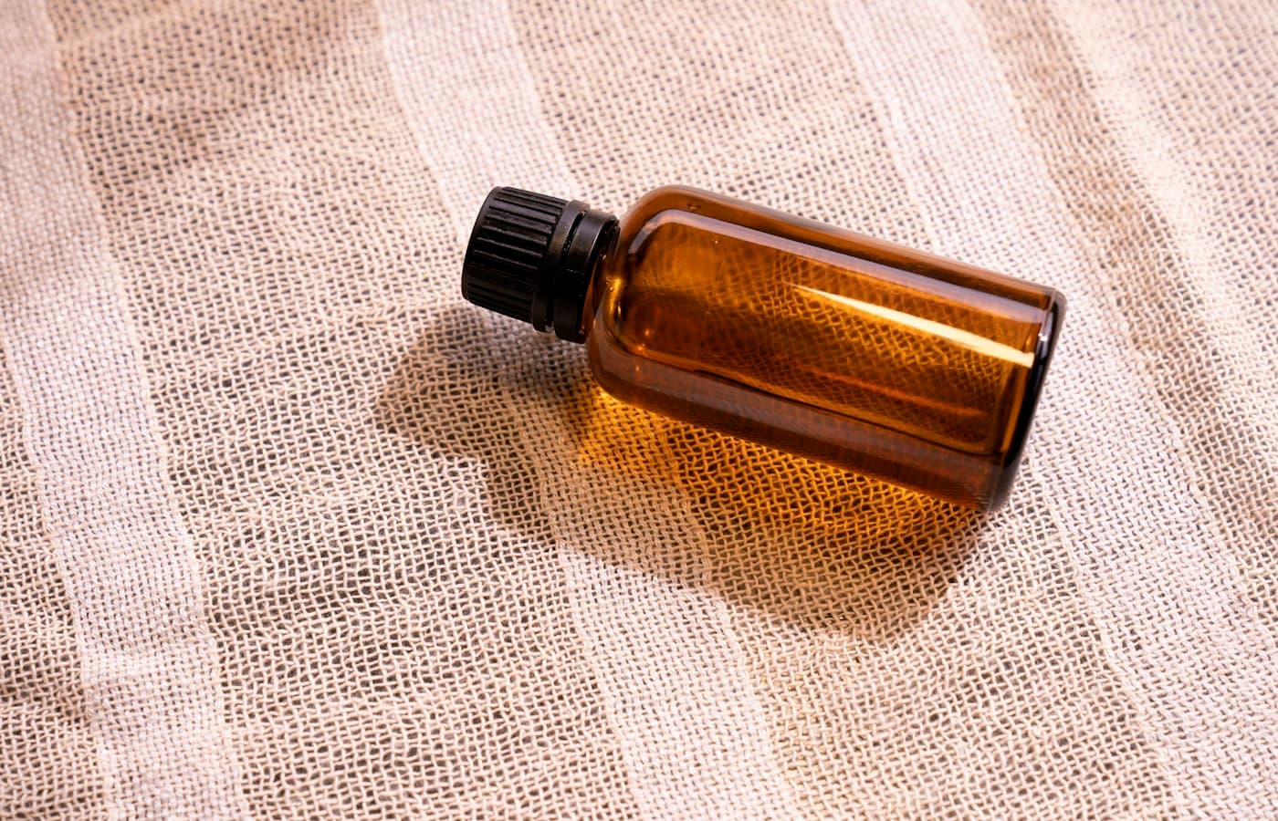 A bottle of essential oil sitting on a cloth