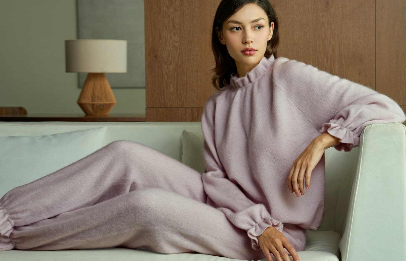 Woman in light purple pajamas relaxing on sofa