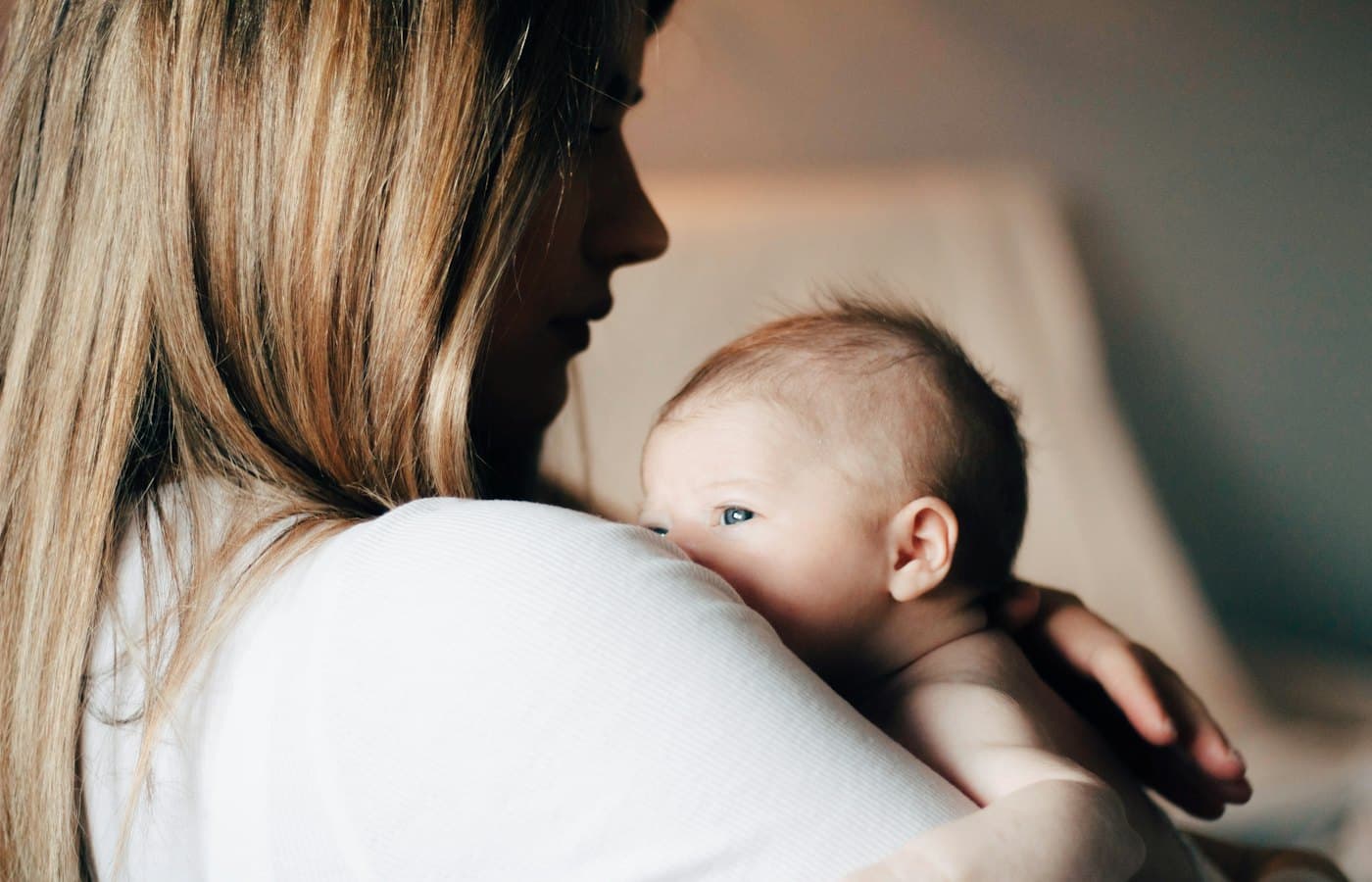 Woman in white shirt carrying baby