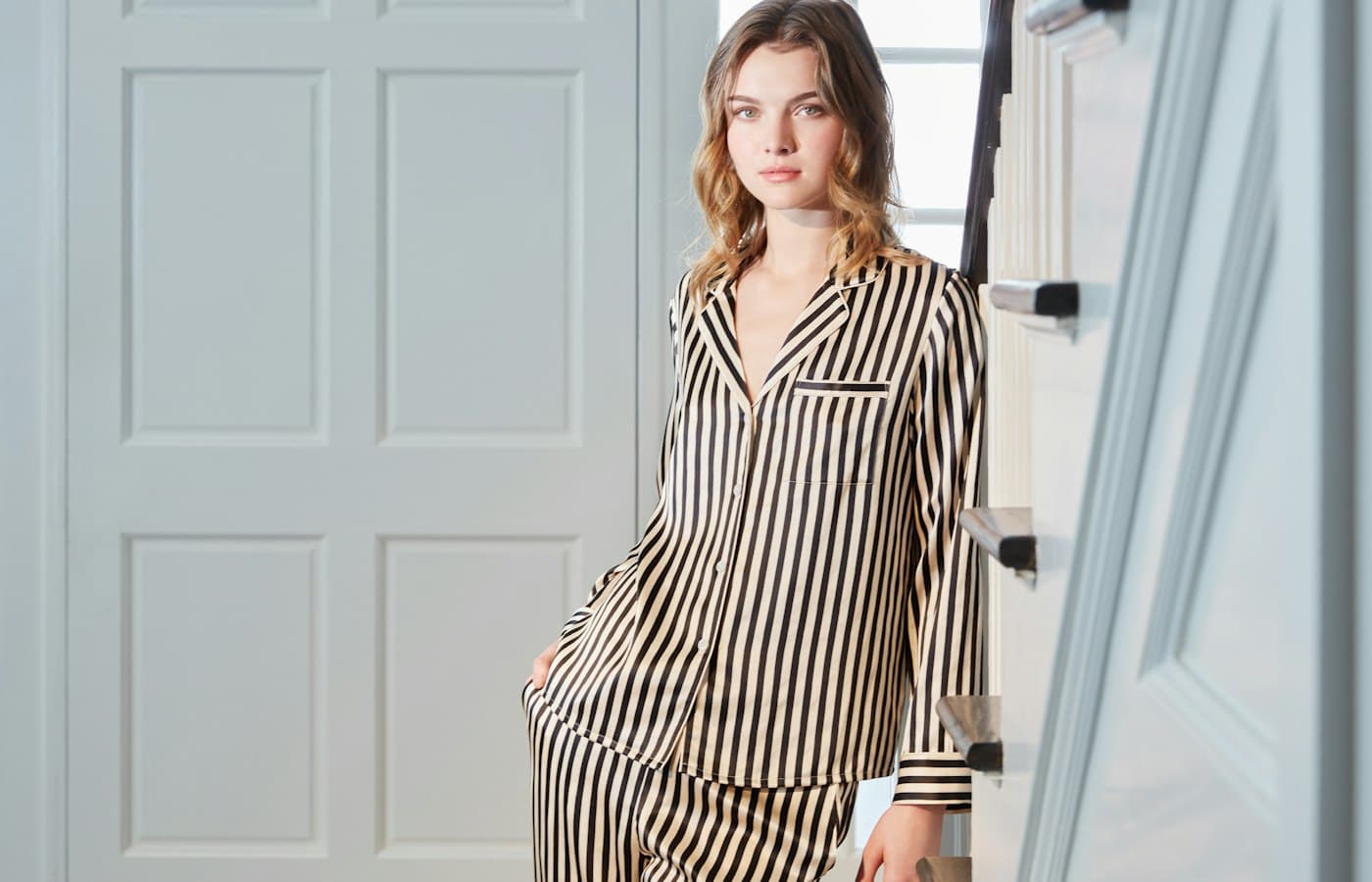 Young woman wearing striped pajamas indoors