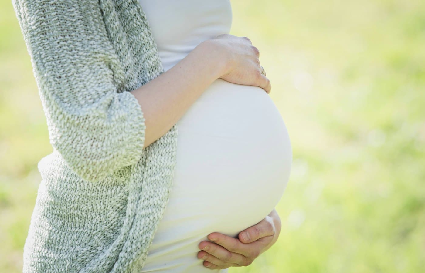 A pregnant woman holding her belly in her hands