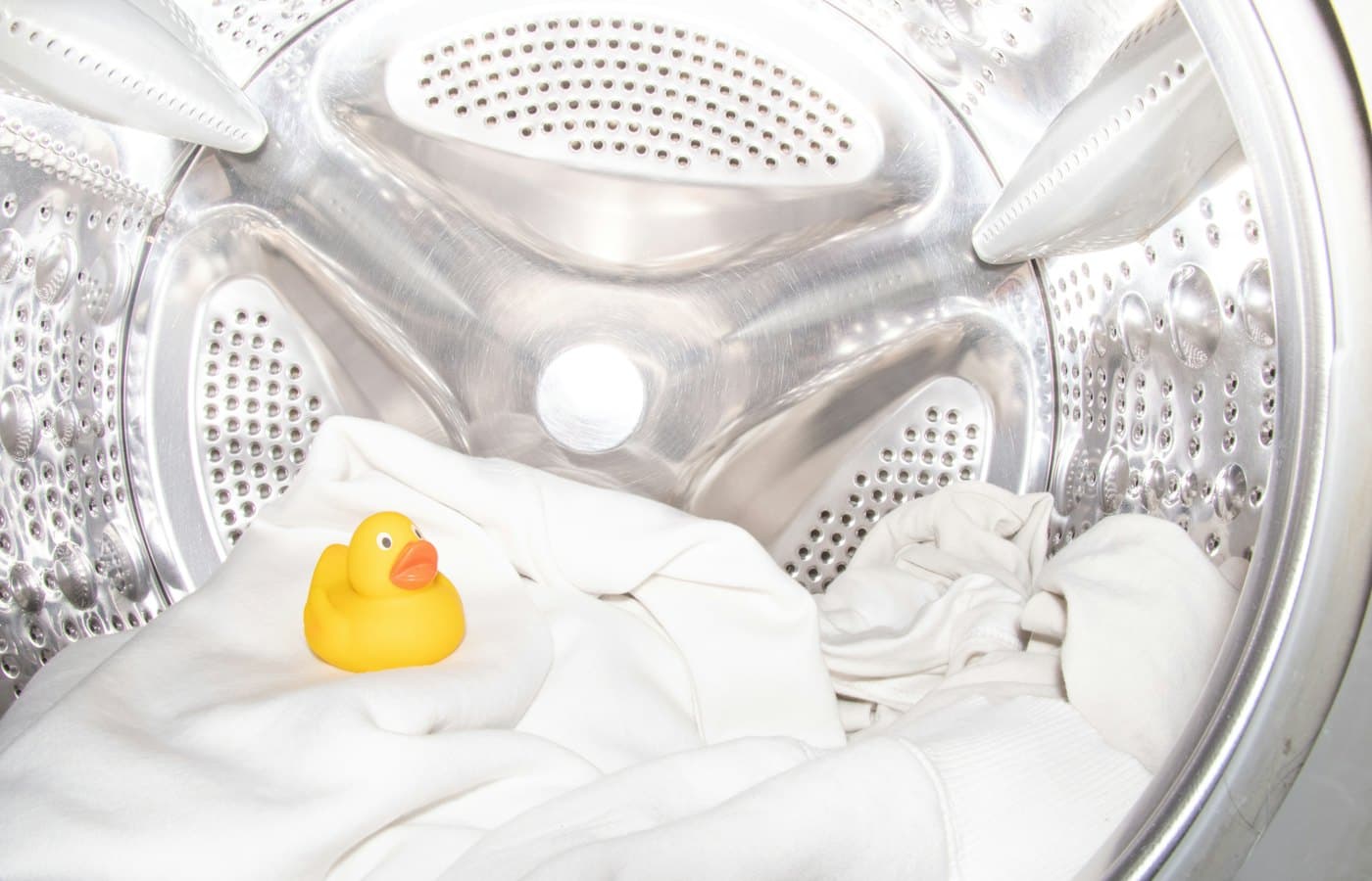 A rubber ducky toy sitting inside of a washing machine