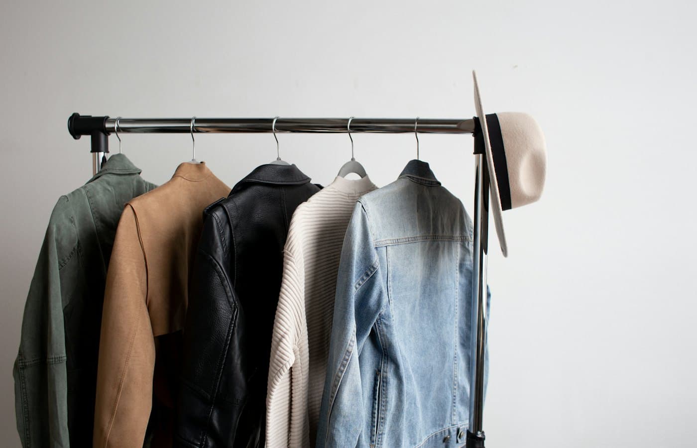 One cowboy hat and five jackets hanged on clothes rack