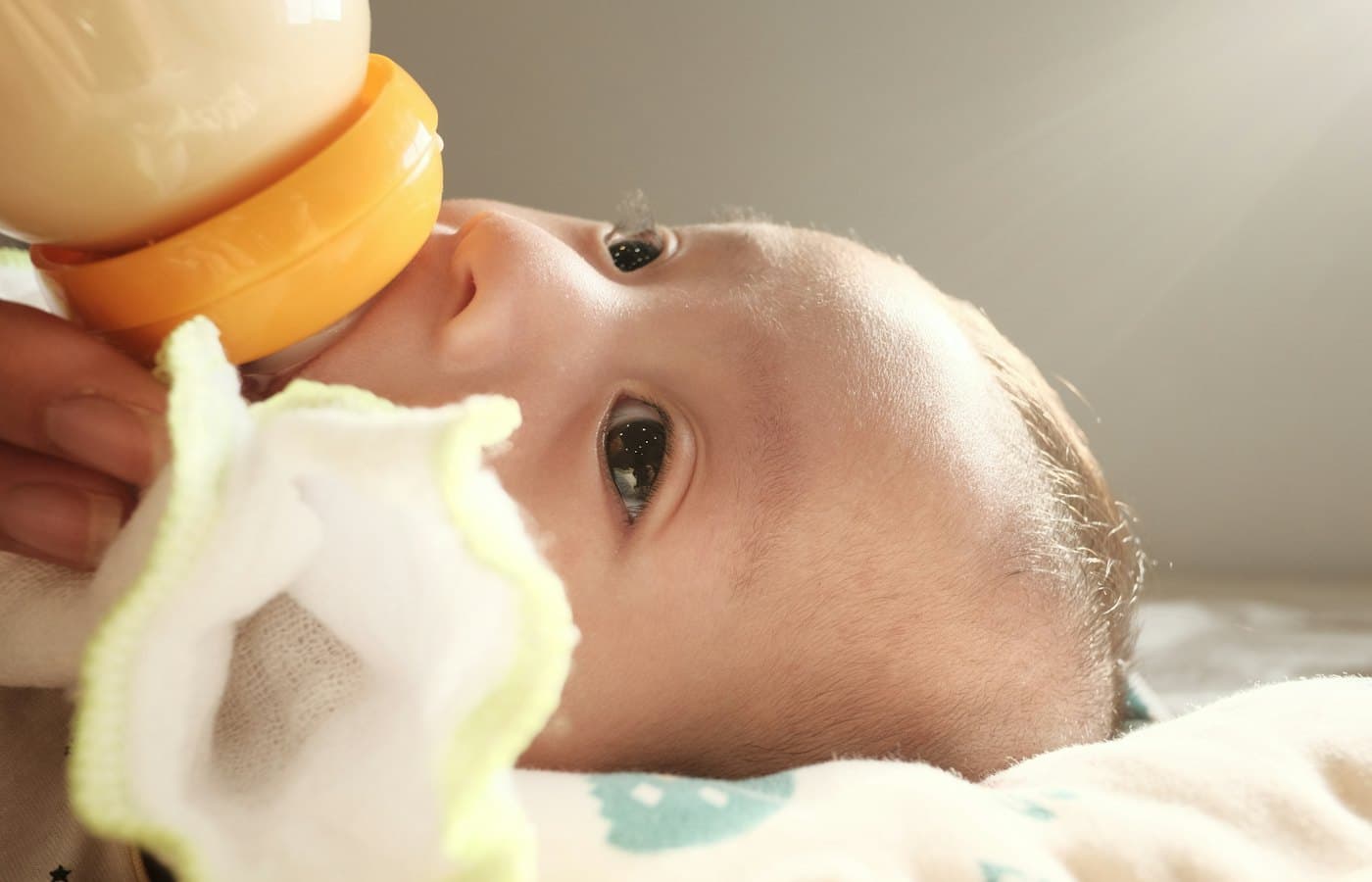 A baby laying on a bed with a pacifier in its mouth