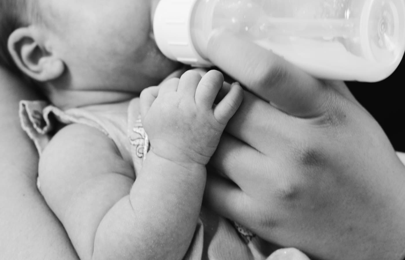 Grayscale photo of baby feeding