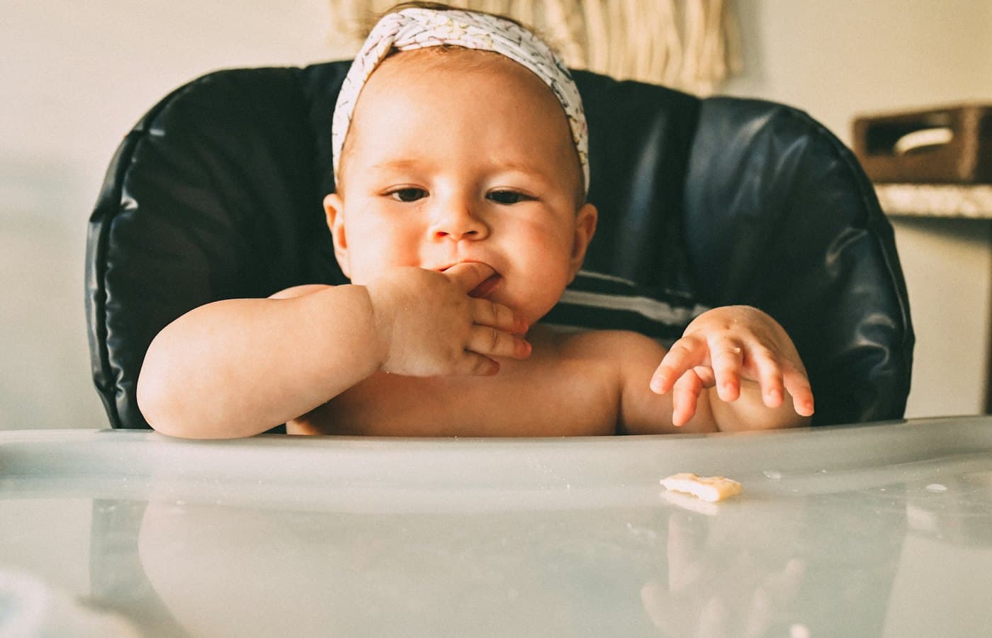 A baby sitting in a high chair eating food